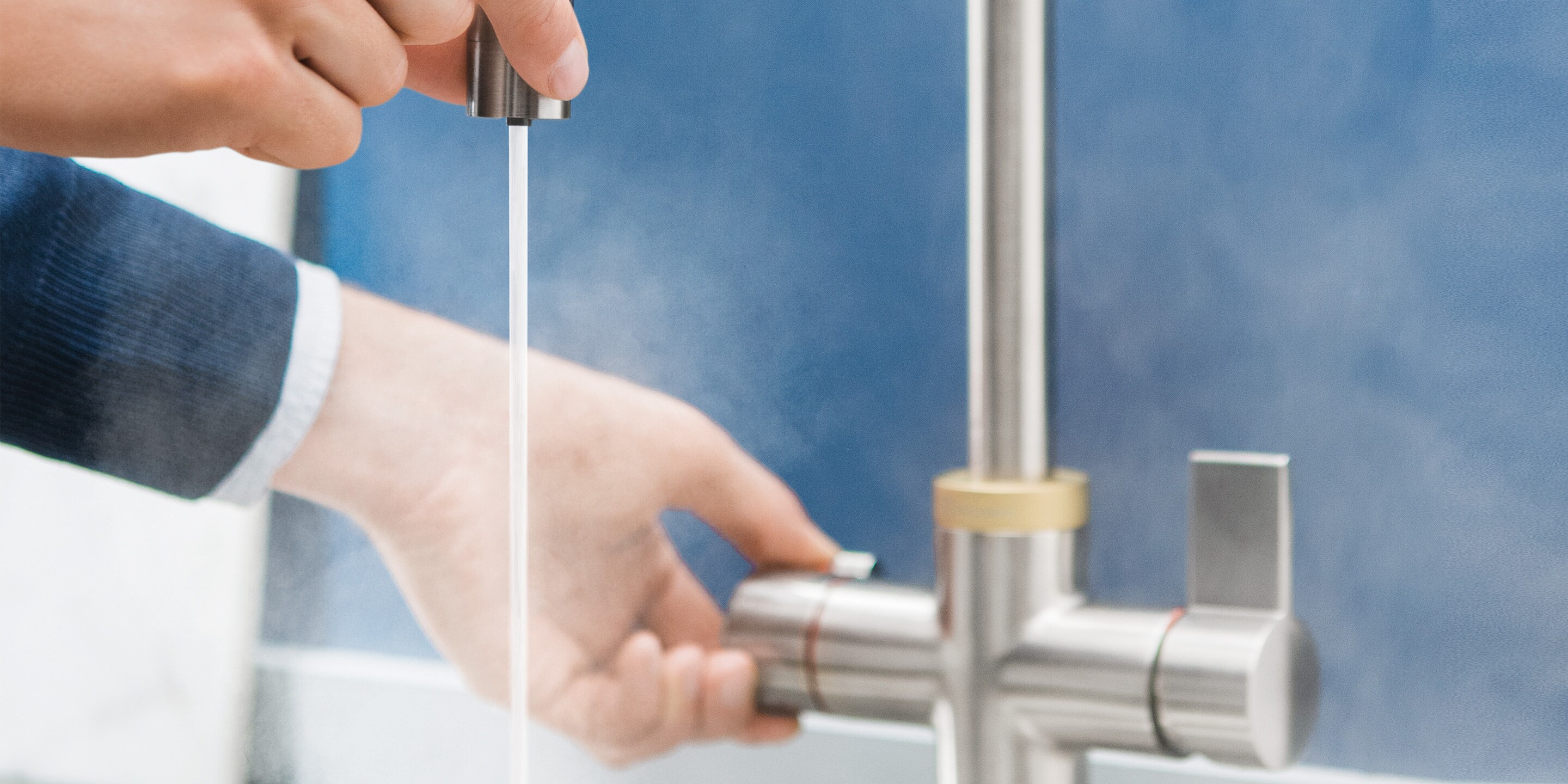 Мужчина без опасений касается изолированного носика крана Electrolux QuickSource