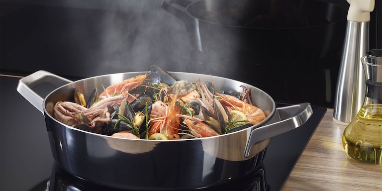 Пар, поднимающийся из кастрюли в вытяжку