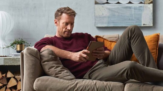 Man sitting in sofa with his phone using the My Electrolux Care App