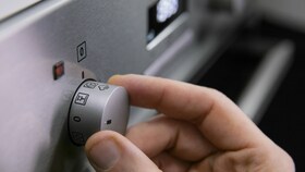 Пекар, який встановлює налаштування духової шафи на PlusSteam, готуючись до випікання заварного крему
