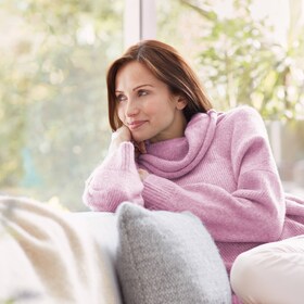 Женщина радуется своему шерстяному джемперу