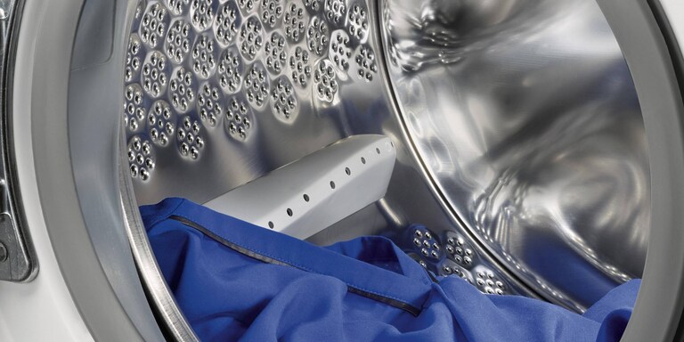 Изображение, показывающее зазор, который следует оставлять между одеждой и верхней стенкой барабана