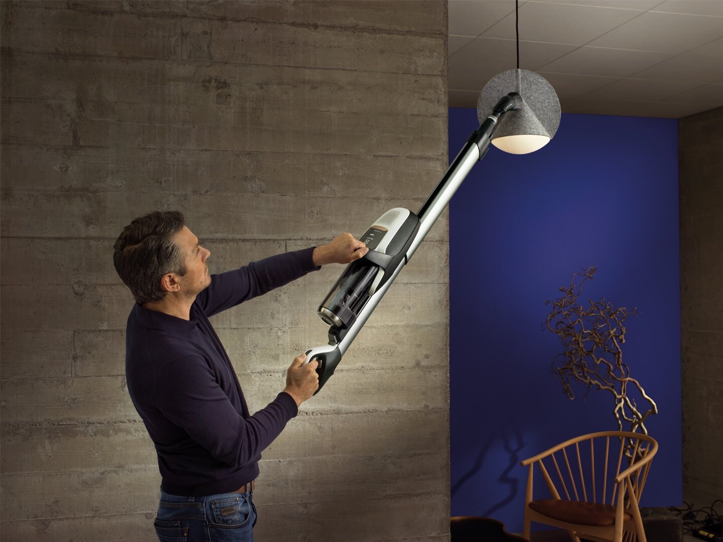 man cleaning lamp with vacuum brush tool